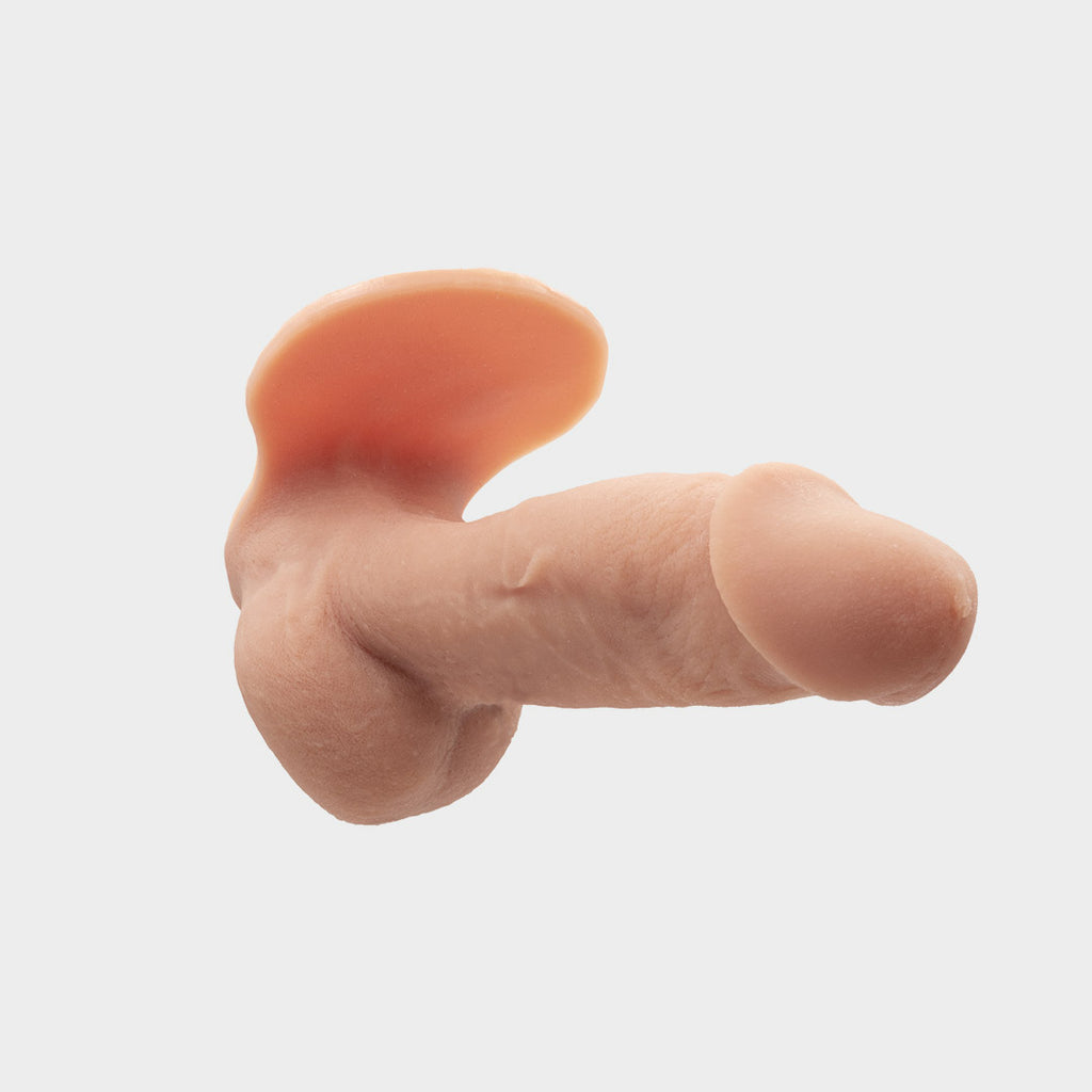 A realistic hard penis play prosthetic with veins and realistic skin features. Brand Banana Prosthetics. Side front view.