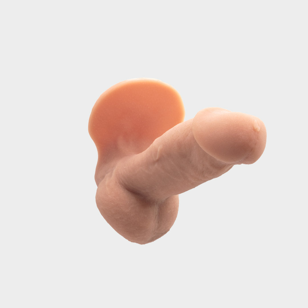 A realistic hard penis play prosthetic with veins and realistic skin features. Brand Banana Prosthetics. Front view.