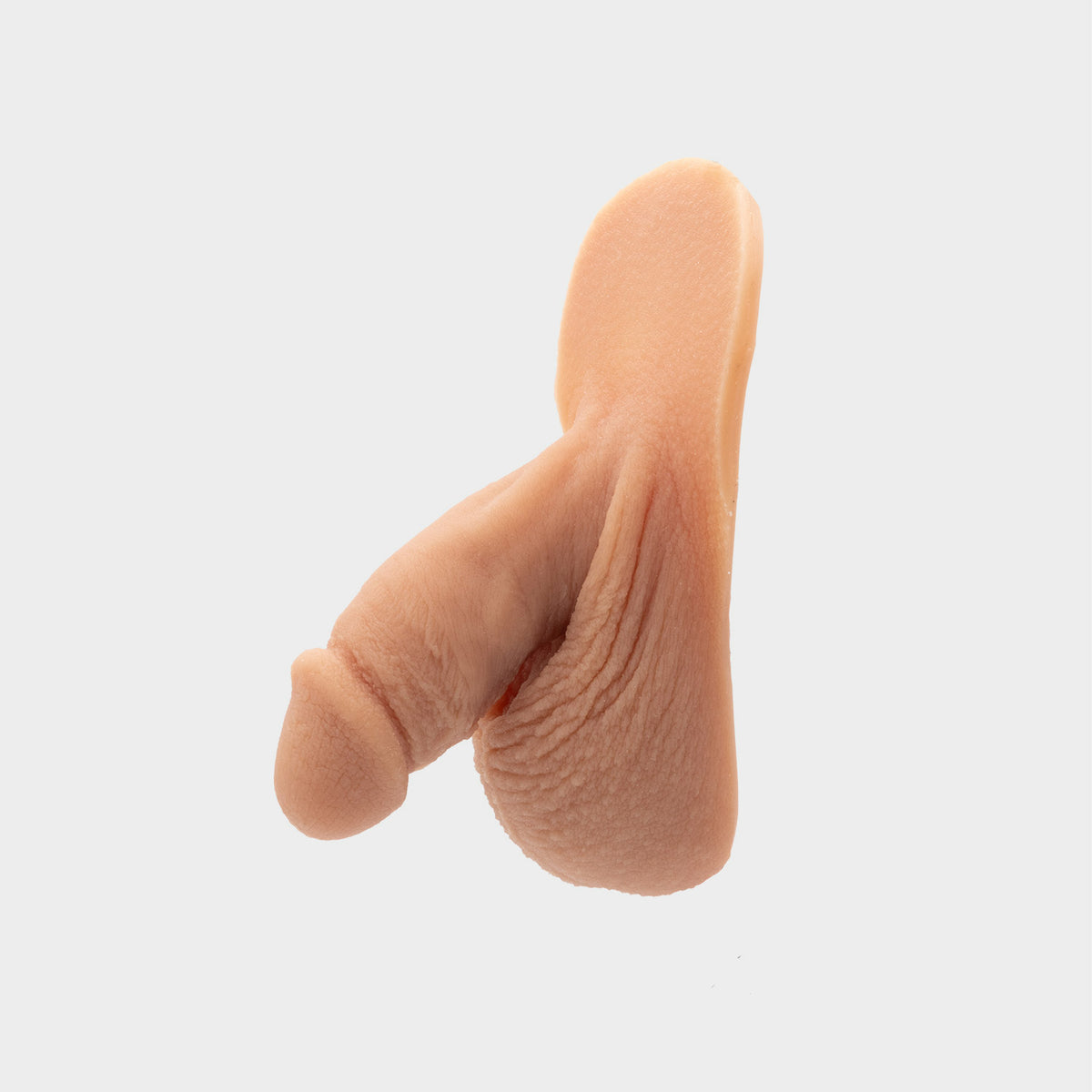 Realistic packer from Banana Prosthetics made of silicone featuring veins, wrinkles, realistic look of a flaccid penis. For trans men, trans masc, nonbinary, ftm people. Side close view