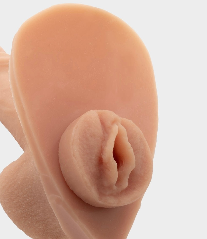 Side close-up vide of the sensation plug featuring a vulva, inserted in the hard penis prosthetic of Banana Prosthetics.