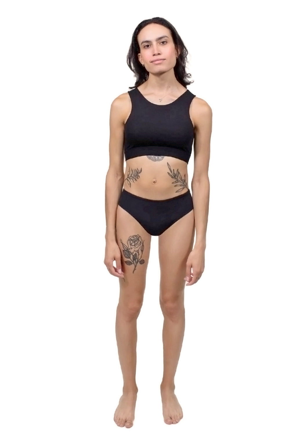 A trans AMAB person wearing tucking underwear gaff in black. View from the front.