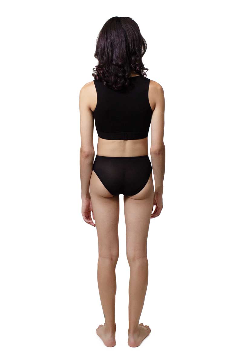 A trans AMAB person wearing hipster gaffs for tucking. Color black. View from the back.